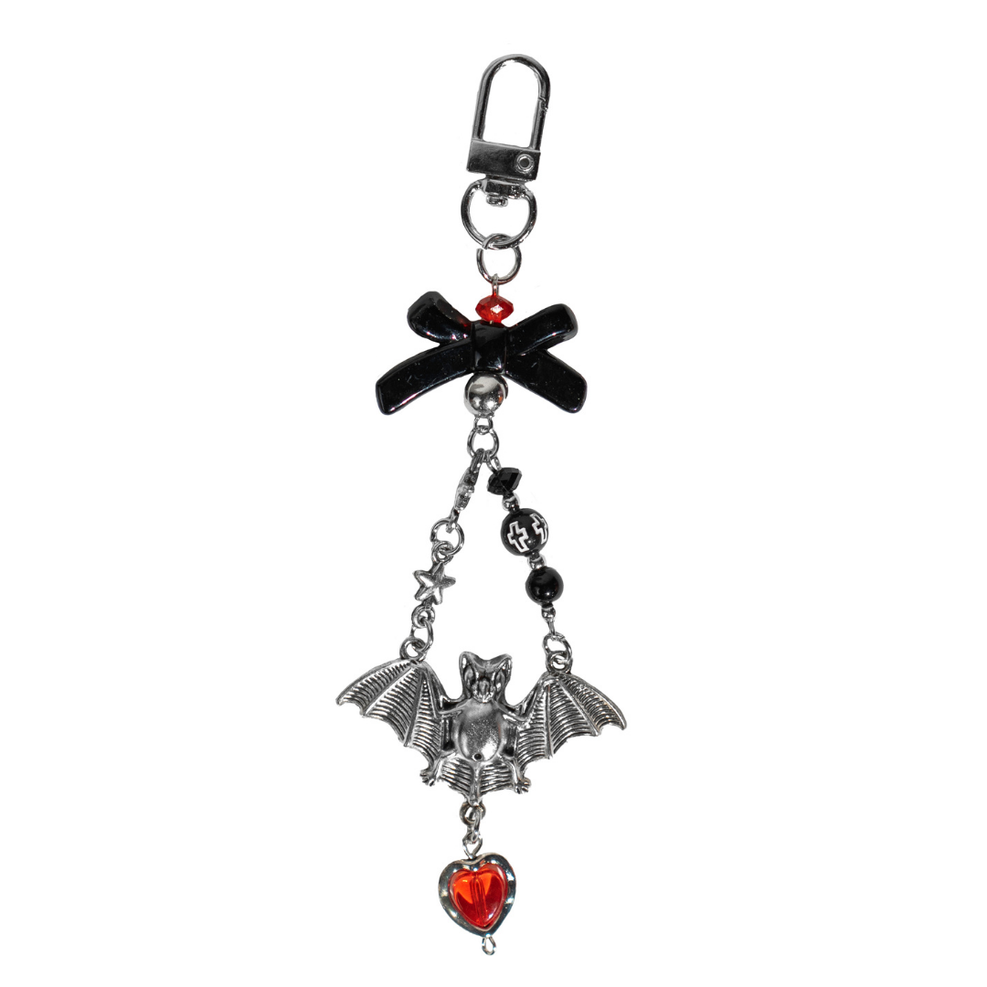 CharCharms gothic bottle charm featuring black bow, silver bat pendant, and red heart gem accent on a white background