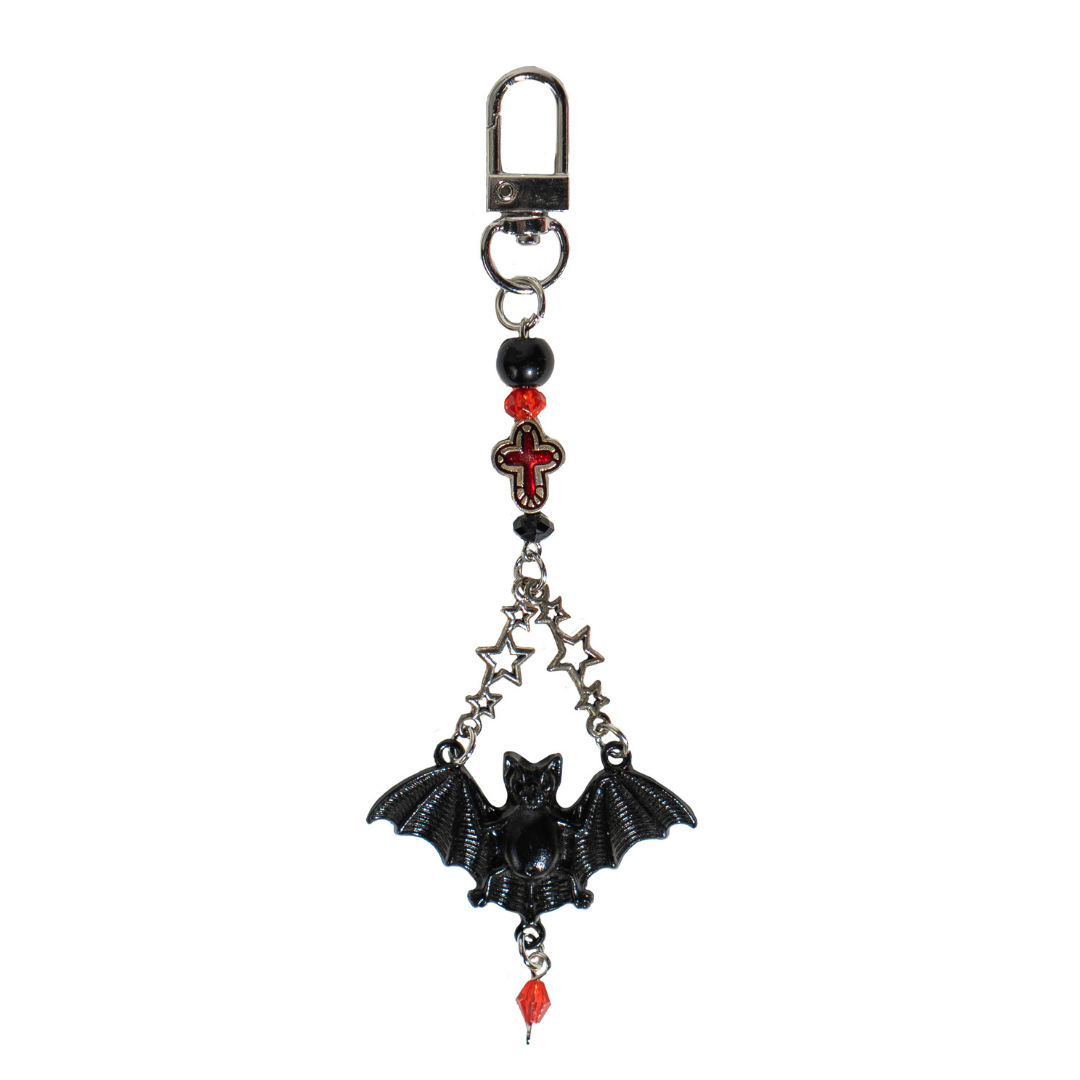 CharCharms gothic bottle charm featuring black bat pendant, silver star chain, and red cross bead on a white background