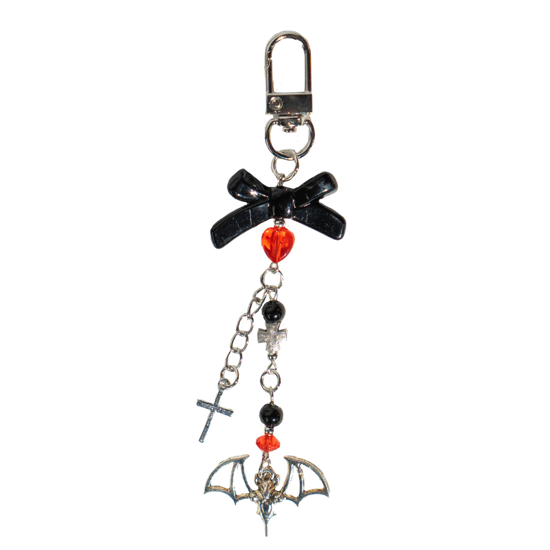 CharCharms gothic-style bottle charm featuring black bow, red heart bead, silver cross, and bat pendant on a white background