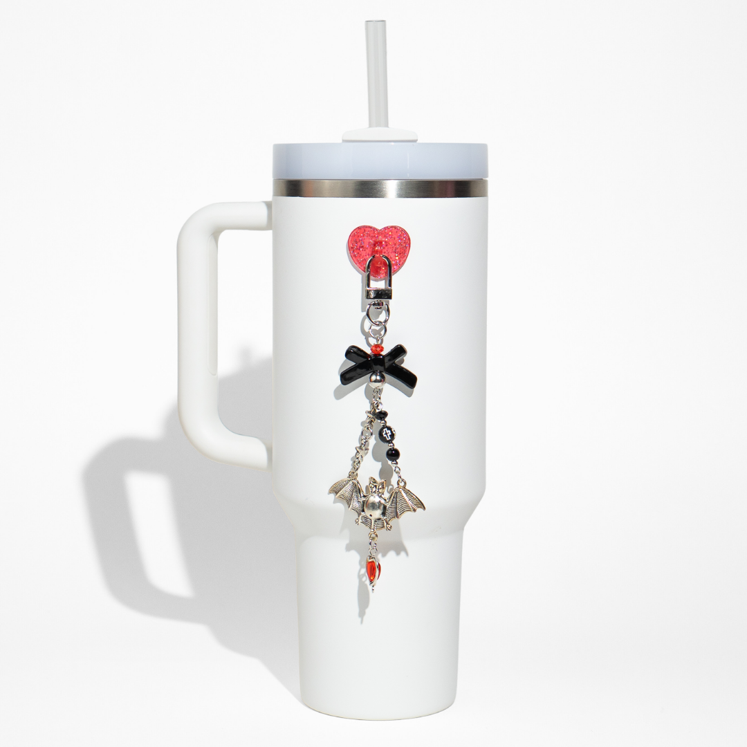 White tumbler featuring a gothic heart bottle charm set with black bow, bat, and red accents from CharCharms