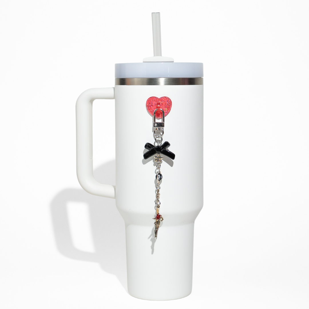 White tumbler featuring a red glitter heart clip and black bow bottle charm with silver chain details from CharCharms
