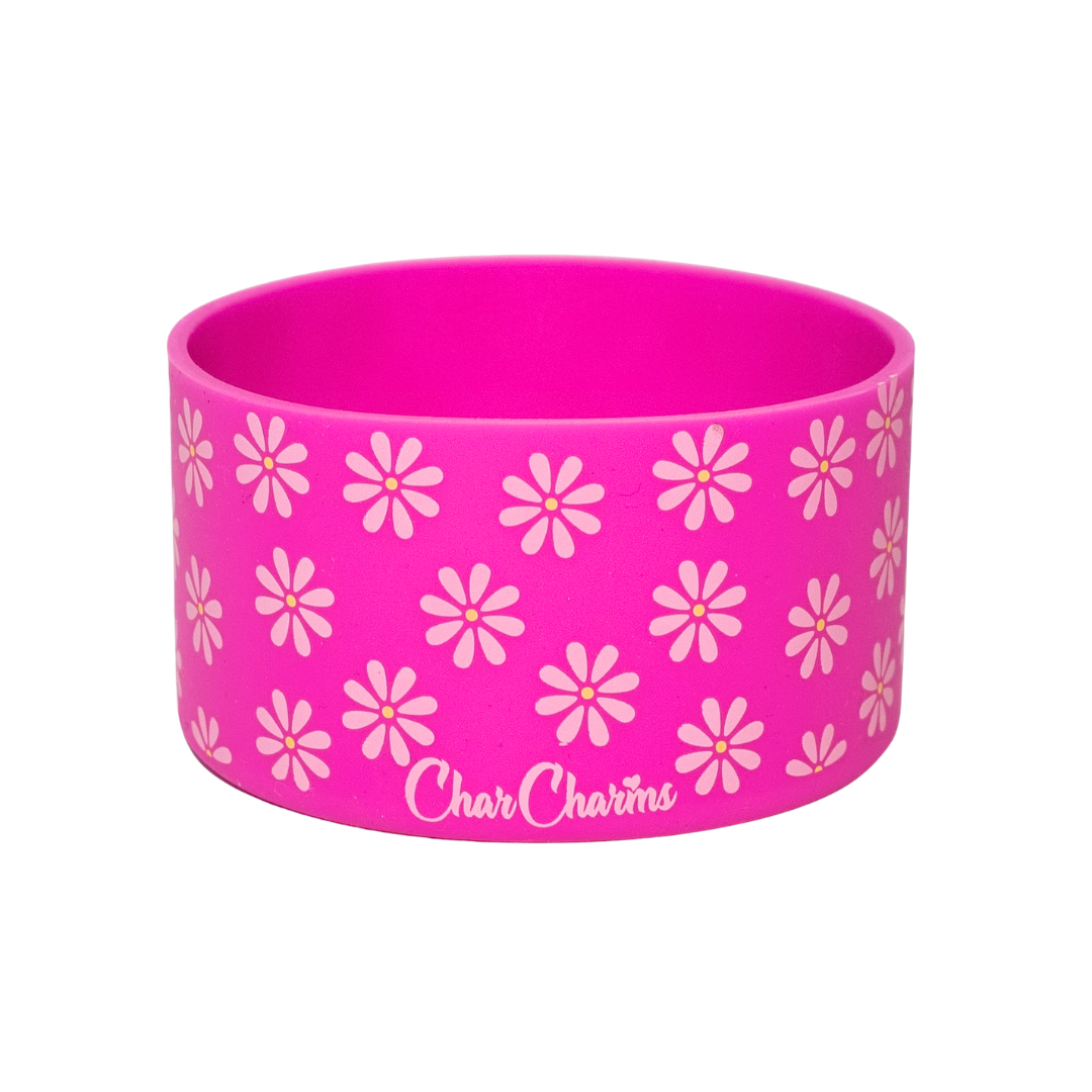 Pink silicone wristband with white floral pattern and 'Charm Charms' branding on a white background